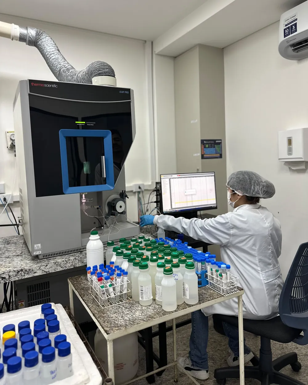 Analista operando o espectrômetro ICP Thermo Scientific iCAP PRO, usado na determinação de metais, no laboratório da Conágua Ambiental